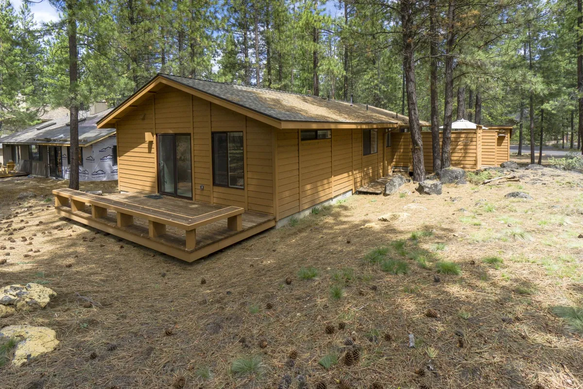 A peaceful shot of the wooden deck and large windows, set against the backdrop of natural surroundings. This space is ideal for outdoor family gatherings, post-adventure relaxation, or simply soaking in the Sunriver atmosphere.